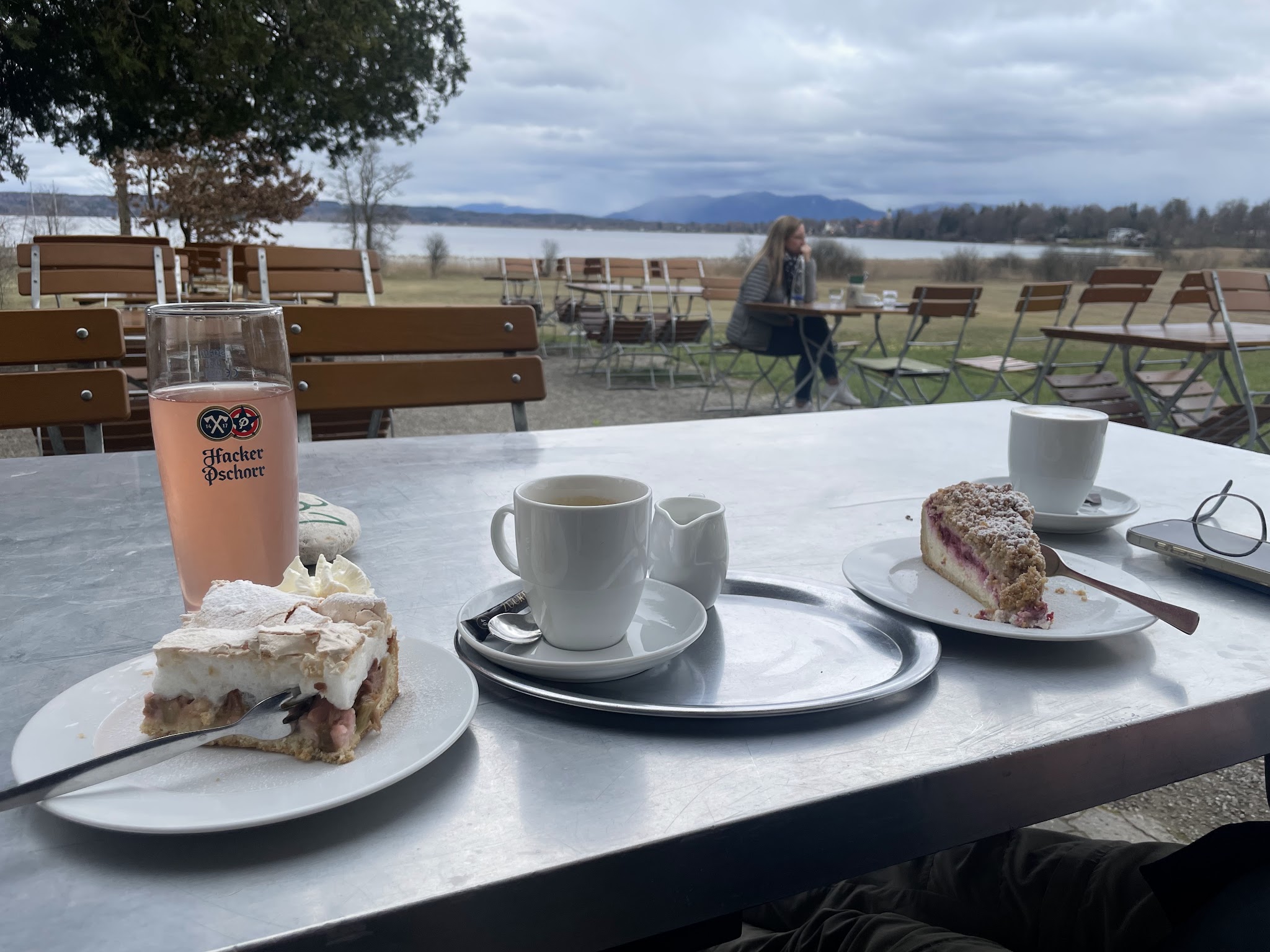 Kuchenteller und Kaffee auf dem Tisch, dahinter der Starnberger See
