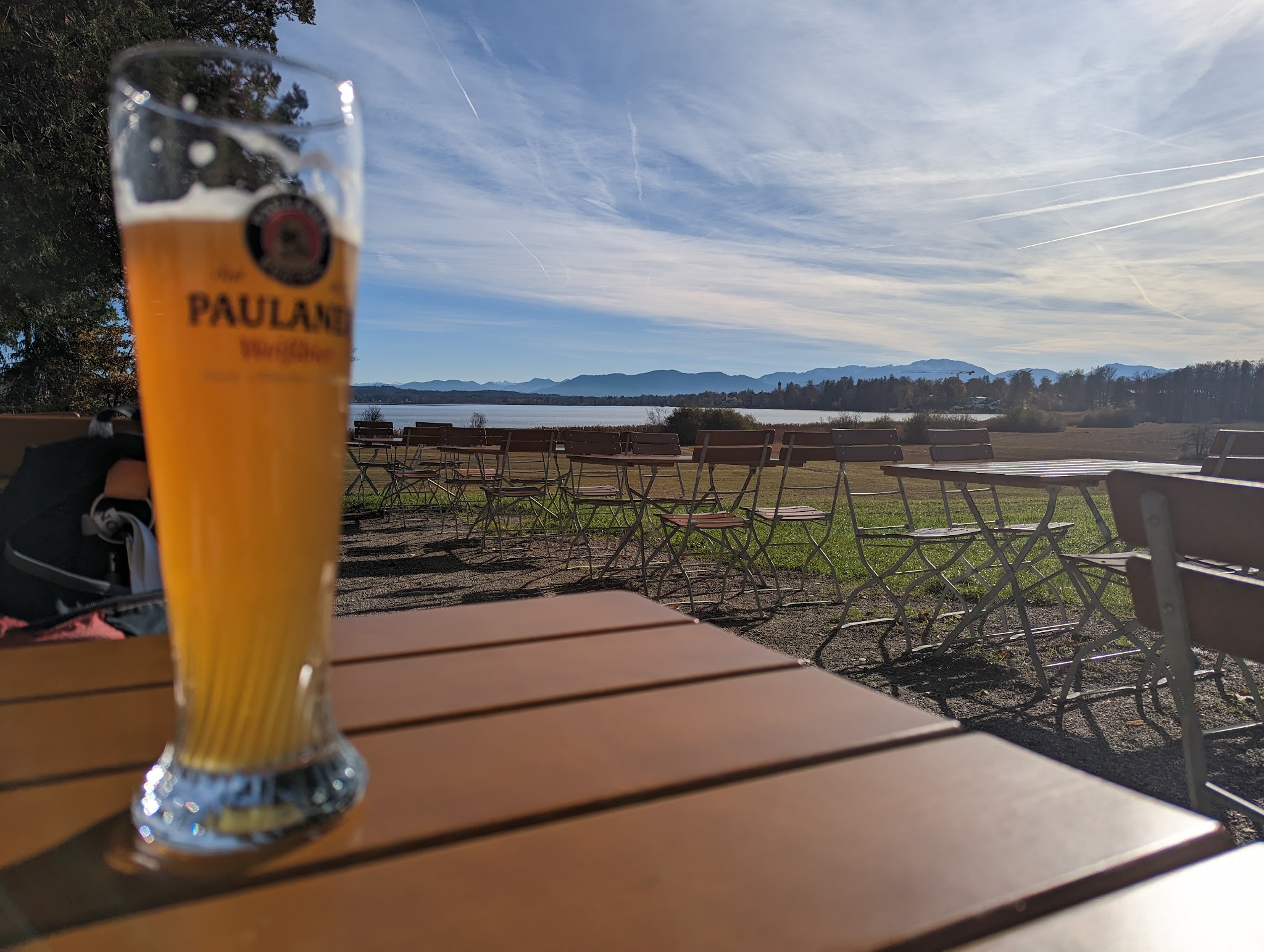 Biergarten des Gasthofs Seeseiten am Ufer, dahinter der Starnberger See und die Berge